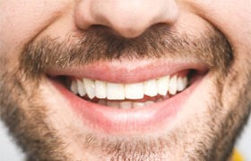 Close-up of a bearded man smiling