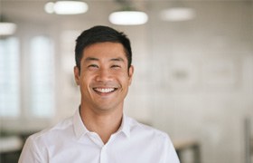Man in a white shirt smiling in an office