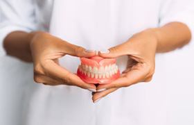 Lady presents viewer with dentures