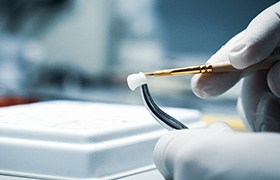 A lab worker refining a dental crown