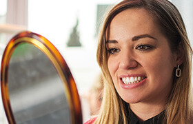 Woman looking at smile in mirror