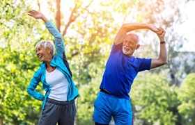 couple wearing exercise clothing and stretching outside