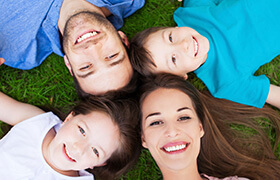 Smiling family of four outdoors