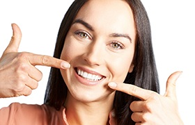 woman pointing to her teeth after gum sculpting in Aurora.