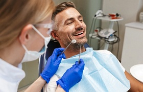 Man completing dental exam from an implant dentist in Aurora