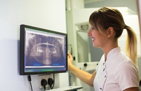 Dentist examining patient’s dental implants in Aurora