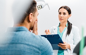 Dentist explaining treatment for a failed dental implant in Aurora