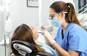 dental hygienist cleaning a patient’s teeth