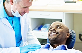 Man in dental chair smiling at dentist