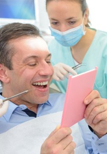 man smiling in dental mirror 