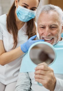 man smiling in dental mirror 