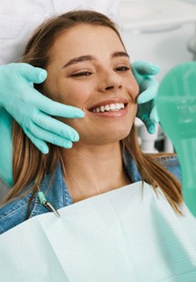 patient smiling in dental mirror 