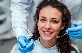 woman with curly hair smiling in dental chair 