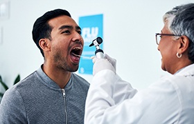A dentist performing an oral cancer screening