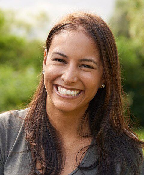 Young woman grinning outdoors