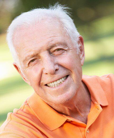 Senior man smiling and wearing orange polo shirt