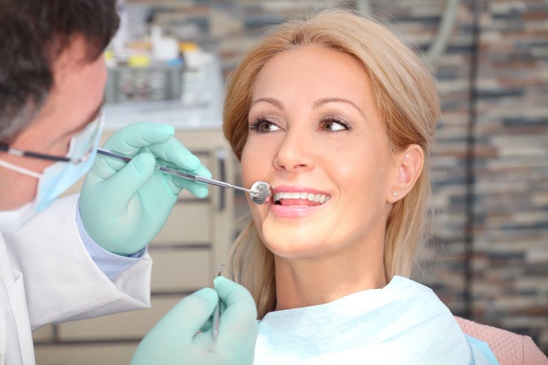 A woman having her teeth and gums checked by a dentist