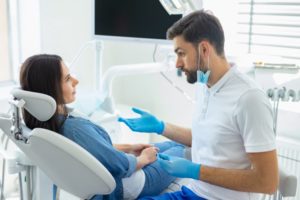 Dentist speaking to woman sitting in dental chair