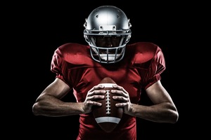 Football player with helmet and holding football