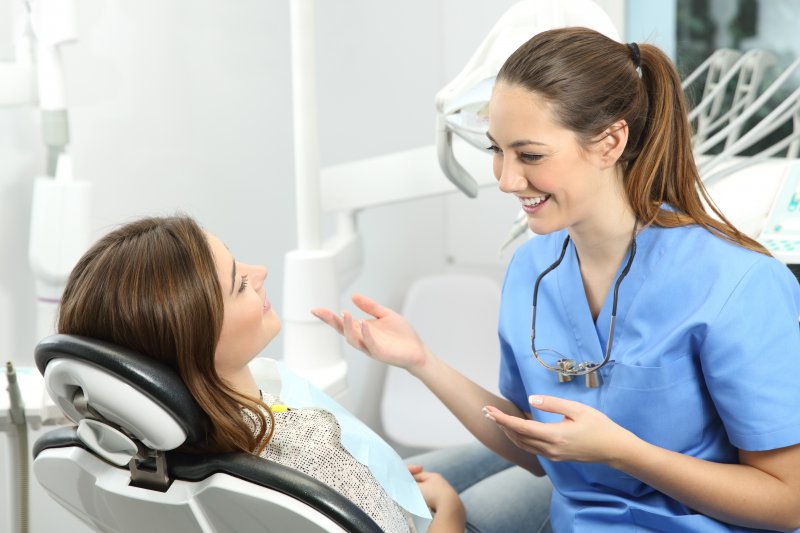 patient about to undergo tooth extraction talking to dentist 