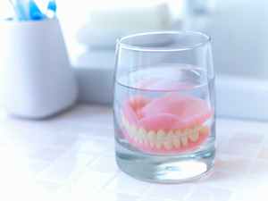 Dentures soaking in a glass