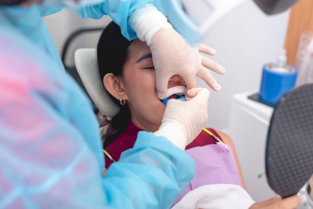 Dentist inserting tray of fluoride into patient's mouth