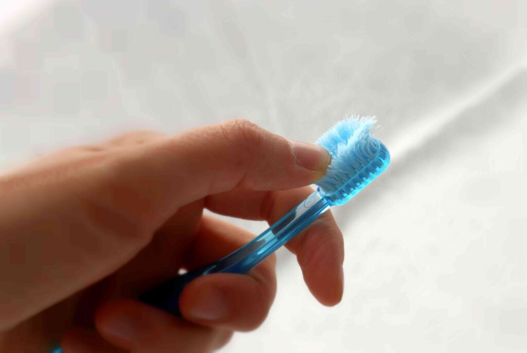 Holding a frayed toothbrush