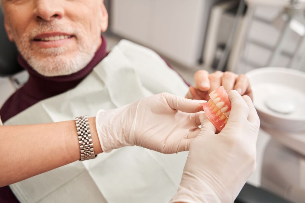 Man in dental chair receiving new set of dentures