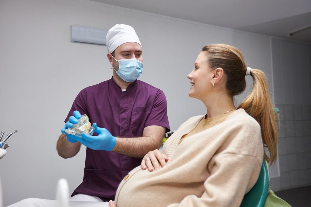 A pregnant woman talking to her dentist